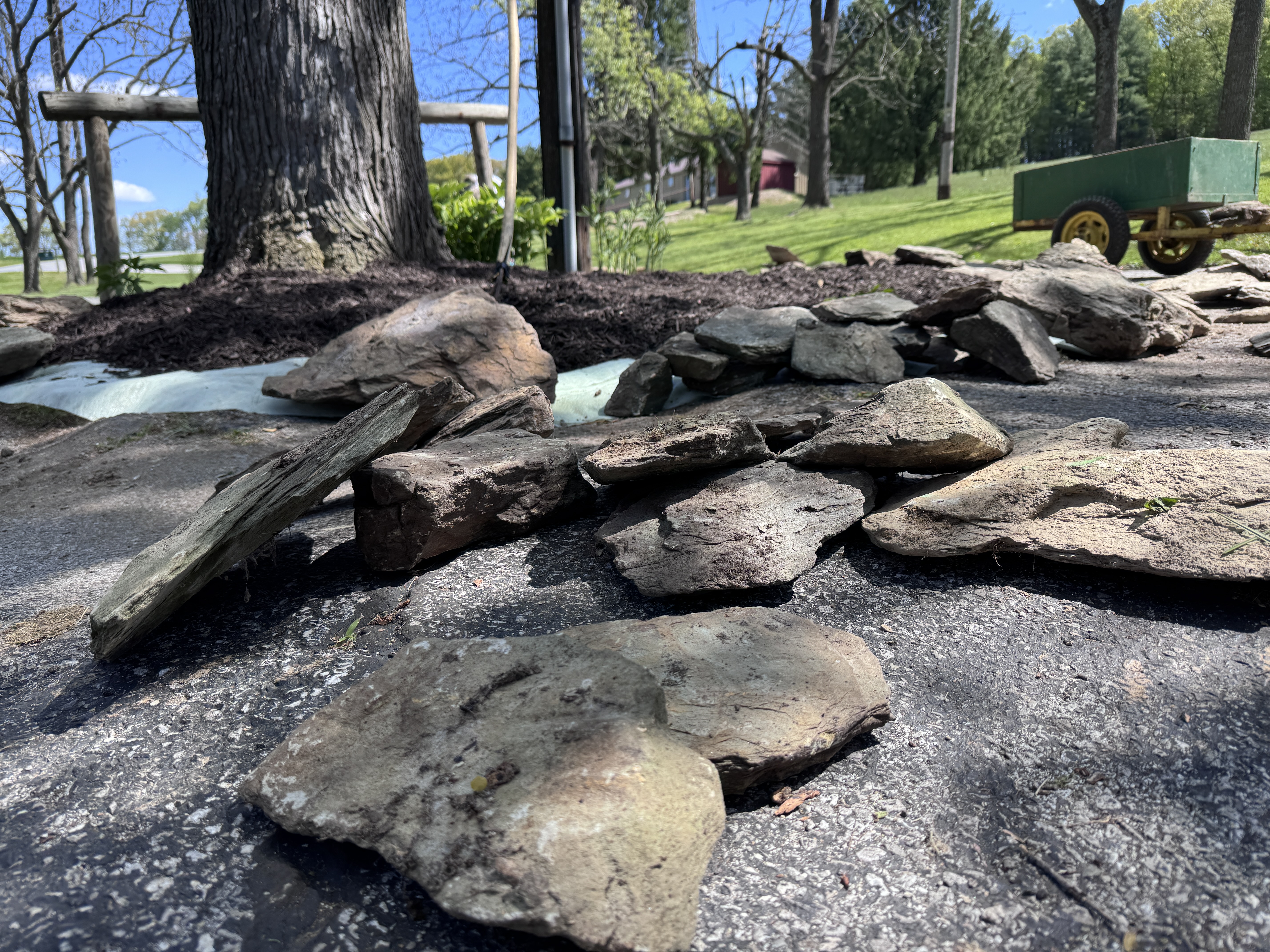 Low-angle view of flat fieldstones spread across the driveway, island and ATV beyond